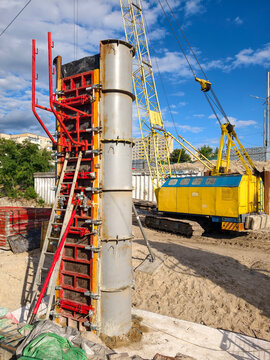 Construction site, yellow crawler crane and reinforced concrete bridge pier concreting using modular formwork demonstrating structural mechanics and controlled load distribution in civil engineering