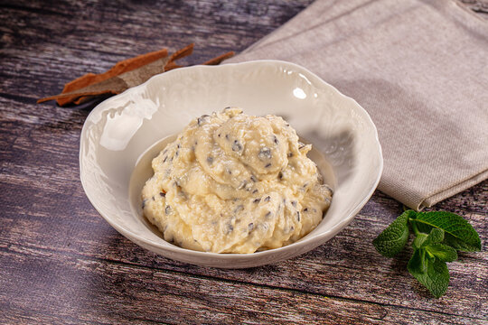 Homemade quark or cottage cheese dessert with poppy seeds in white bowl on rustic wooden table