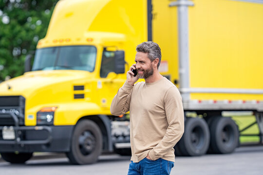 Man driver use phone at lorry truck. Tracking delivery. Truck driver. Trucking owner planning route. Tech logistics. Hispanic man control truck. Man owner truck driver. Transportation logistic
