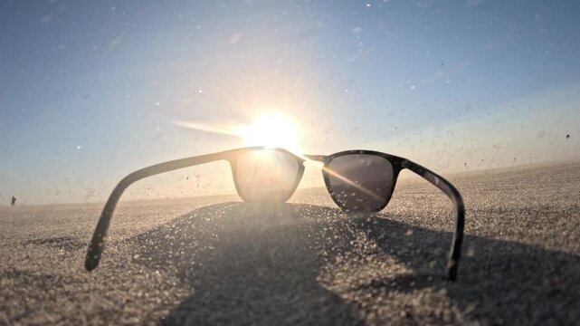 Immersive sunset scene with sunglasses, windswept sand and colorful kites over the North Sea at Kijkduin