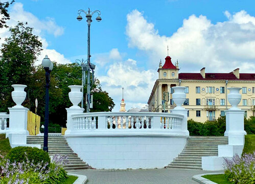 Classic white stone balustrade and staircase in Gorky Park Minsk Belarus with iconic stalinist empire architecture building under blue sky for european travel blog city tour banner and historical heri