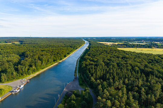 Cargo ship passing through canal in Germany. Transport logistics. Canal aerial view. Travel and logistics. Kiel canal aerial footage. Inland waterway