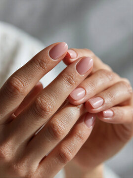 Close-up of a nail technician's hands with manicured nails