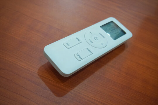 Modern White Air Conditioner Remote Control On Wooden Table