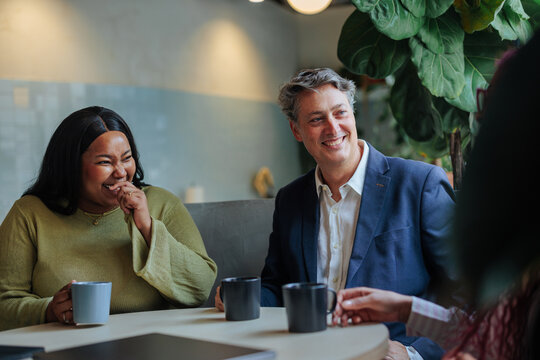 Diverse business colleagues having a happy discussion over coffee