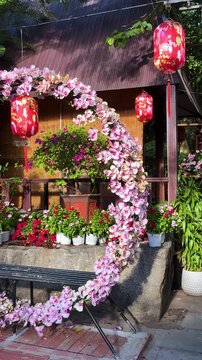 Da nang, lady buddha, ornamental gate decorated with delicate pink flowers and festive red lanterns, creating an inviting entrance for celebrations