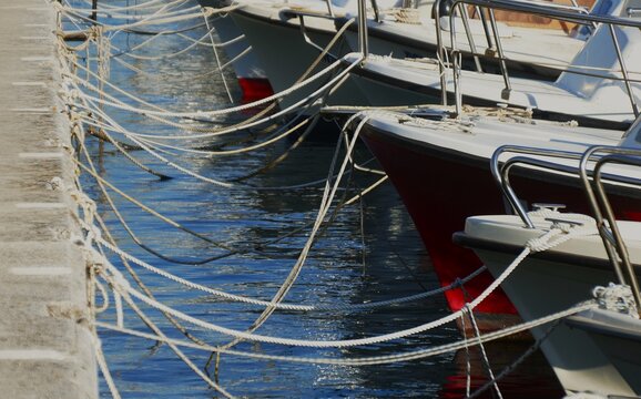 Boats in a peaceful harbor tied up with ropes, marine and nautical background