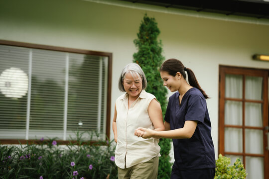 Professional caregiver assisting a senior woman during an outdoor walk, promoting mobility, balance, confidence, and independent aging.