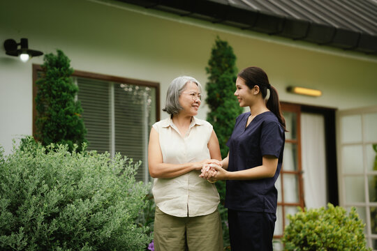 Professional caregiver assisting a senior woman during an outdoor walk, promoting mobility, balance, confidence, and independent aging.