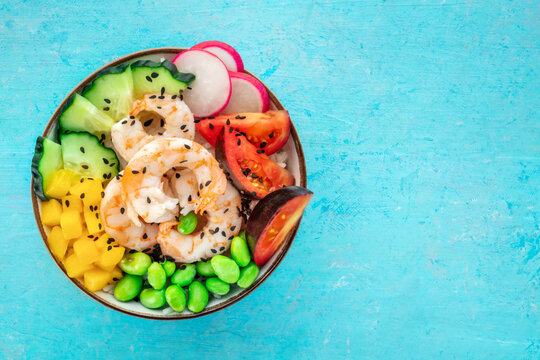 Poke bowl with shrimps, tomatoes, cucumber, mango, edamame, and radish