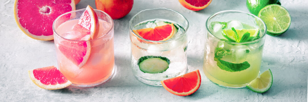 Refreshing summer cocktails with ice cubes on a light background