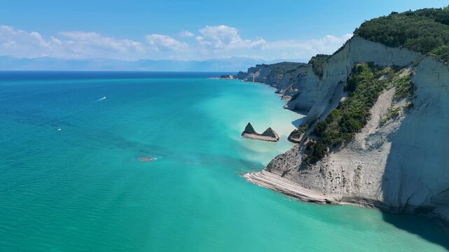 Drone flying over turquoise water and white cliffs at Loggas beach in Corfu