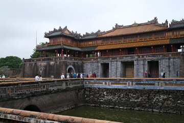 Fototapeta premium Tourists walking across the historic bridge at Hue Imperial City entrance in Vietnam