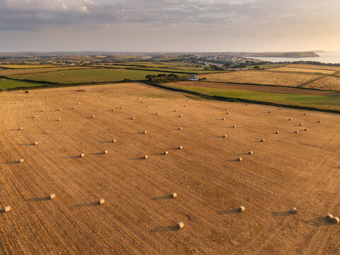 Beautiful drone landscape image of Pentire Headland and The Rumps in Cornwall and surrounding countryside during colorful Summer sunset