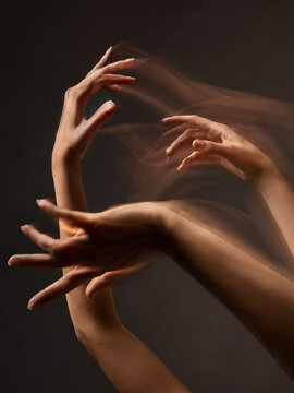 Two hands in motion, fingers spread apart, creating a dynamic and fluid image emphasizing movement and interaction.