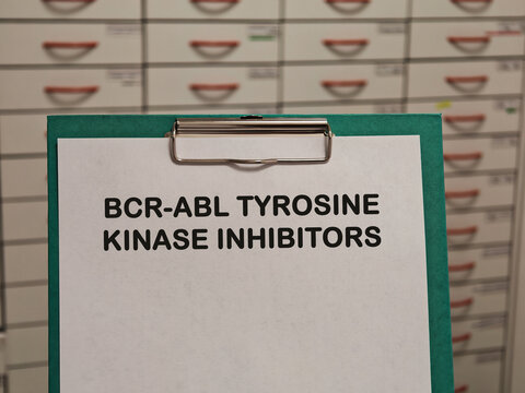 BCR-ABL TYROSINE KINASE INHIBITORS medication name displayed on a clipboard in a pharmacy