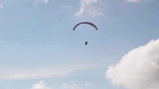 People try paragliding flying with parachutes against clouds