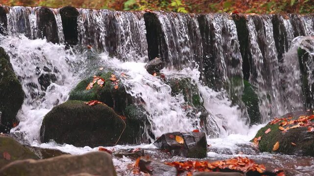 Large boulders overgrown with moss at waterfall