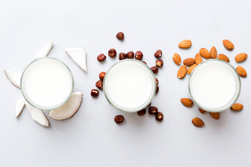 Naklejka premium Set or collection of various vegan milk almond, coconut, cashew, on table background. Vegan plant based milk and ingredients, top view