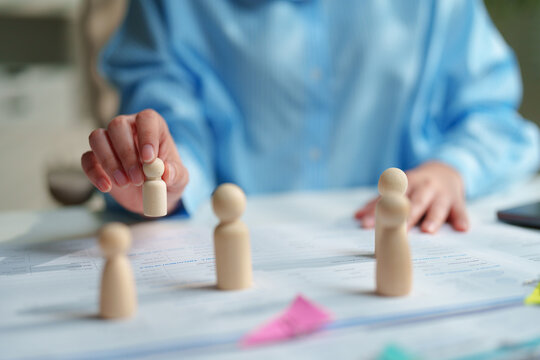 Human resources and talent management concept with wooden figures on business documents, recruitment, team building, employee development, and strategic workforce planning