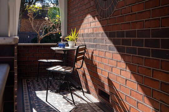 Cozy Urban Balcony Sunlit Brick Wall Seating