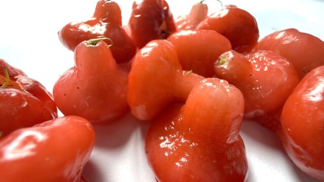 Vibrant red rose apples close up on a simple white background