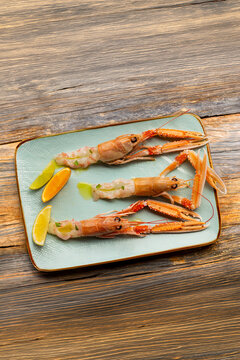 Fresh raw whole langoustine scampi with lemon on plate restaurant Adriatic seafood raw fish
