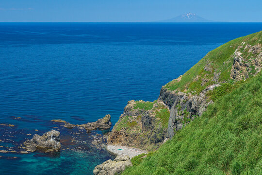 北海道天売島の断崖と青い海 越しに望む利尻島の絶景