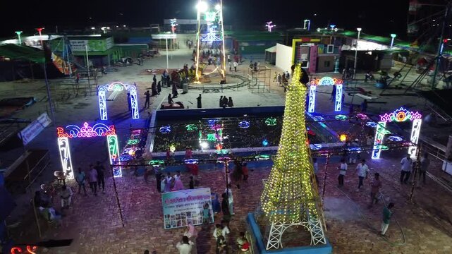 Aerial night view of carnival festival grounds with glowing tower and archways fairground lights arch illumination neon fairground lights arch illumination neon