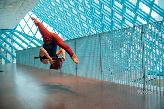 Woman jumping and reading a book inside the Seattle public library 