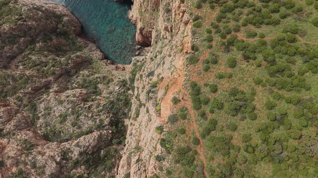 Dramatic Limestone Cliffs Of Miniere nel Blu (Mines in the Blue), Coastal Trekking Route In Southwestern Sardinia, Italy. Aerial Topdown Shot