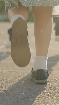 Girl wearing black shoes with white socks. The girl is standing on a sidewalk