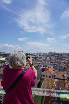 A senior woman enjoying porto's view and taking a picture