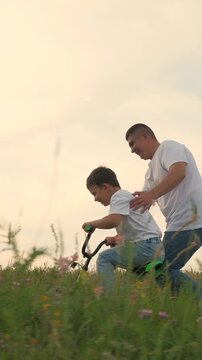 man father teaches boy son ride bike, schoolboy boy playing happily dad park, father running after bike child green meadow, happy family outdoors, children dream, adrenaline fast cycling, childhood