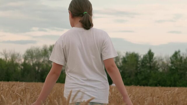 teenage girl walking wheat field, agriculture, child enjoying nature wheat field, child girl farmer daughter walking field touching ears wheat, freedom childhood dream, childhood outdoors, walk