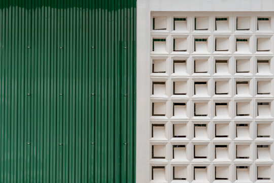 Green corrugated metal wall and white breeze block ventilation wall geometric texture background.