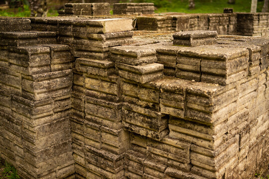 Detailed view of weathered concrete interlocking paver blocks stacked in a grooved pattern, perfect for landscape design, masonry, and outdoor hardscaping.