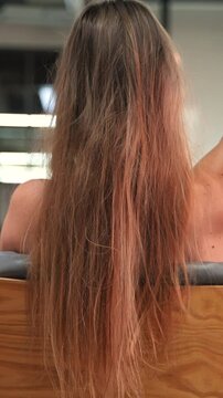 Woman's hair texture. Close-up view of a girl touching her straight healthy blonde hair.