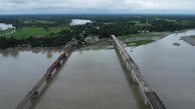 Parallel bridges featuring an old metal truss structure and a modern concrete bridge under construction river aerial infrastructure transportation crossing