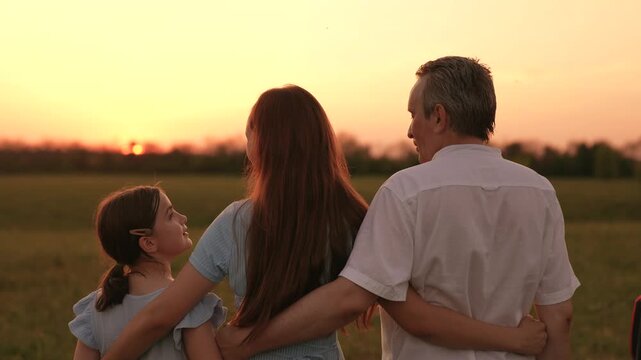 Happy family, father mother child hugging sunset, girl hugging parents man woman sunset, people outdoors nature, embracing loved ones, affectionate outdoor family, caring parental presence, cherished