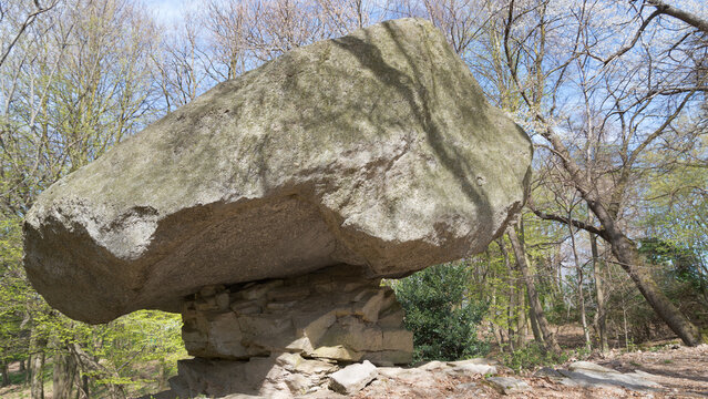 Megalithic stone made of granite in the woods close to the village of Torno, lake Como, Italy. The stone is perfectly balancing on the base, and it is named "Pietra Pendula". Woods in the background.