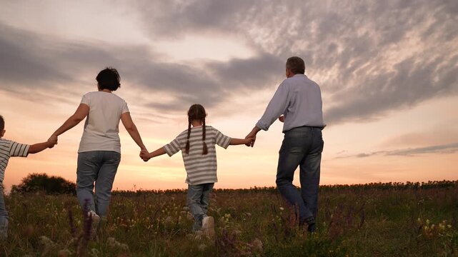 mother father children boy girl park sunset, man woman toddlers outdoors, Family walking in a field at sunset, happy family together outdoors, parents holding hands with children, family enjoying