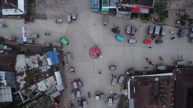 Direct top-down aerial view of a busy road junction with parked buses and moving auto rickshaws overhead traffic vehicles transport transportation overhead traffic vehicles transport