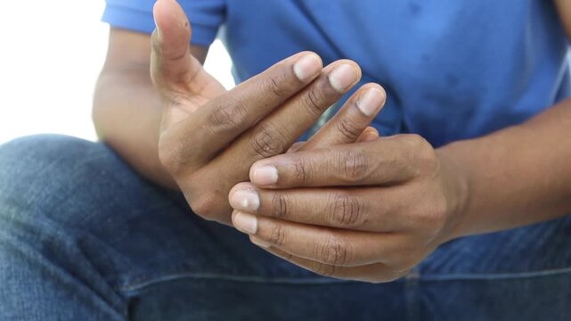 A close up cinematic slow motion shot of a man rubbing his fingers and hands to relax, a daily routine