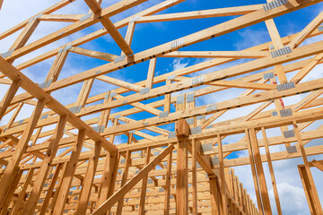 Workers are building wooden frame structure with beams supports under builds new house at...