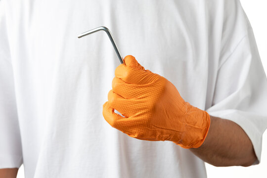 Person holding hex key wearing orange safety glove