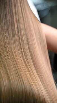 Hairdresser showing results after keratin treatment. Perfect straight hair. Hairstylist showing smooth, straight light brown hair after keratin chemical hair straightening.