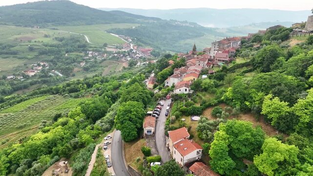 Cinematic drone footage of Motovun medieval town on hilltop in Istria Croatia during early summer with stone houses, green valley, vineyards and authentic European heritage landscape