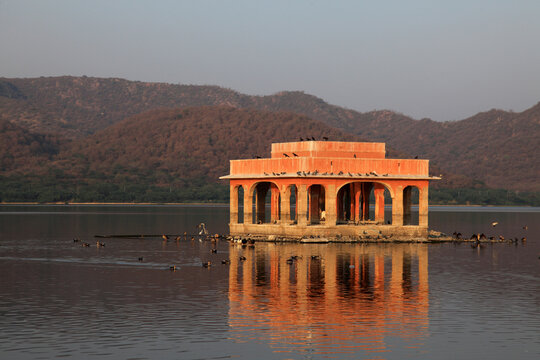 Jal Mahal reflected in the tranquil waters of Man Sagar Lake during golden hour in Jaipur, Rajasthan, India