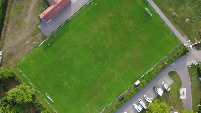 Rotating aerial view of soccer field in Dambach-La-Ville, France. Top down shot ascending from the football pitch.